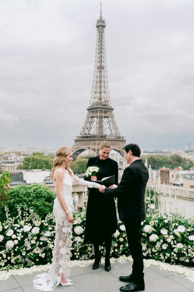 Groom placing wedding ring on Bride in Paris with the Eiffel Tower in the background