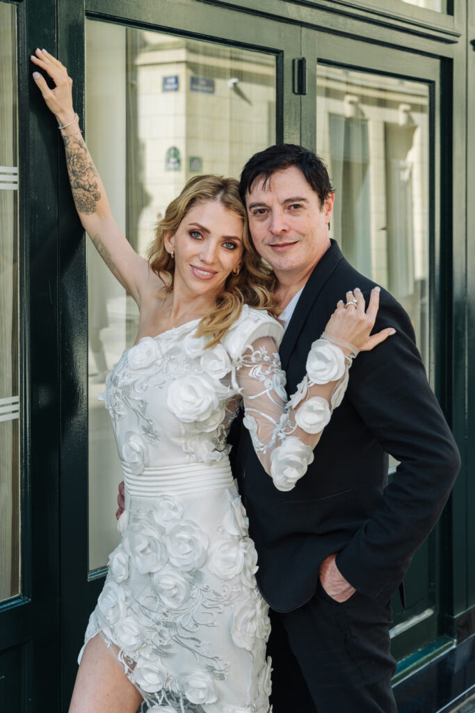 Bride and groom posing outside a Parisian building after their Shangri-La Paris destination wedding, captured by a Fioroni Photography, a destination wedding photographer based in Los Angeles.